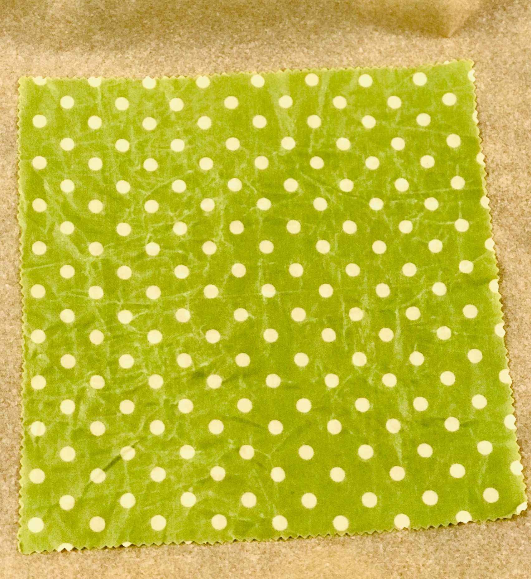 Grünes Wachstuch mit weißen Punkten auf dem Backblech herausgeholt aus dem Ofen.
